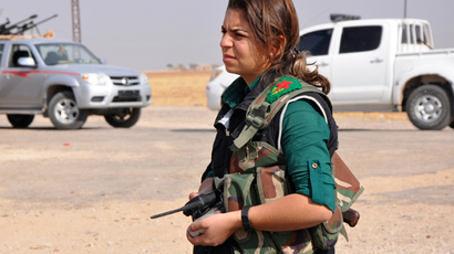 A female member of the Kurdish People's Protection Units (YPG) holds a walkie talkie as she stands along a street in the west of the city of Ras al-Ain, after capturing it from Islamist rebels (Reuters / Stringer)