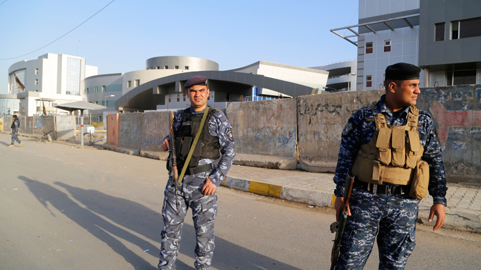 Iraqi policemen stand guard in front of the Ministry of Transportation building after an attack by suicide bombers in Baghdad January 30, 2014. (Reuters / Thaier al-Sudani)