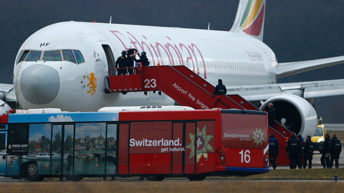 Police officers help a passenger disembark hijacked Ethiopian Airlines flight ET 702 at Cointrin airport in Geneva February 17, 2014.(Reuters / Denis Balibouse)