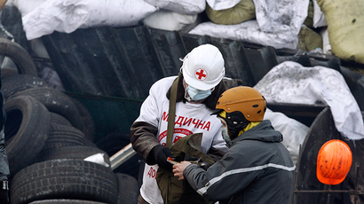 A medical volunteer helps an anti-government protester at the site of clashes with riot police in Kiev (Reuters / Vasily Fedosenko)