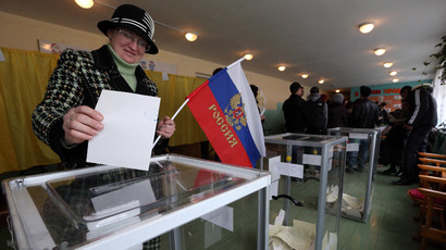 A woman holds a Russian flag as she casts her ballot during the referendum on the status of Ukraine's Crimea region at a polling station in Bakhchisaray March 16, 2014.(Reuters / Sergei Karpukhin)
