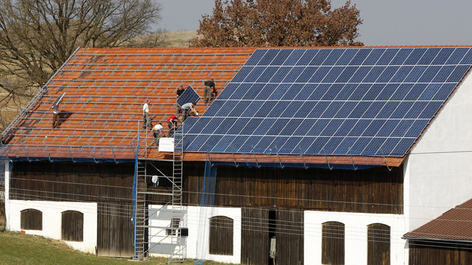 Workers install 320 square metres of solar panels on the roof of a farmstead barn in Binsham near Landshut, Germany (Reuters/Michaela Rehle)