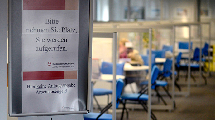 sign tell visitors to wait to be called, as a job seeker is seen speaking with an advisor at the unemployment centre "Agentur fuer Arbeit" (AFP Photo)
