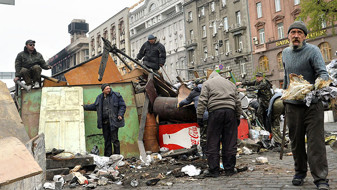 Activists and communal workers dismantle the barricade set on Maidan square during the mass protests of pro-EU opposition against President Viktor Yanukovych regime in Kiev on April 10, 2014. (AFP Photo / Sergei Supinsky)