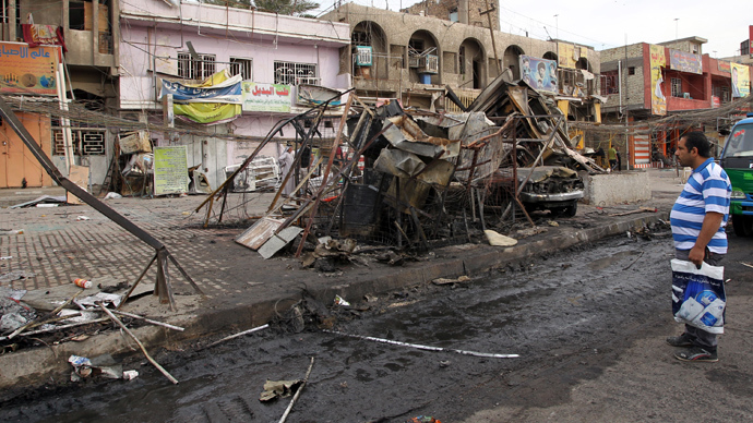 An Iraqi man inspects destruction in the street following an explosion the previous day in Sadr City, Baghdad's northern Shiite-majority district, on April 11, 2014 (AFP Photo / Ali Al-Saaidi)