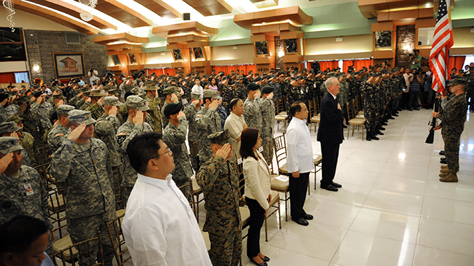 Philippine (R) and US soldiers (L) salute in front of their national flags during the opening ceremony of the Philippine-US annual joint military exercises or locally known as "Balikatan 2014", at the military headquarters in Manila on May 5, 2014 (AFP Photo / Ted Aljibe)