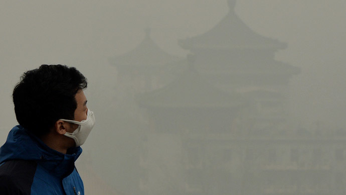 A tourist wearing a face mask climbs Jingshan Hill beside the Forbidden City as heavy air pollution continues to shroud Beijing on February 26, 2014. (AFP Photo/Mark Ralston)