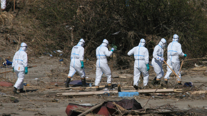 Policemen in radiation proof suits serach for missing victims in Namie, Fukushima prefecture, within 20km from Stricken Tokyo Electric Power Co (TEPCO) Fukushima nuclear power plant on April 17, 2011. (AFP Photo)