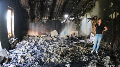 A woman looks at her building destroyed as a result of Monday's combat of Ukrainian troops with anti-government forces near the International airport in Donetsk on May 27, 2014. (AFP Photo / Alexander Khudoteply)