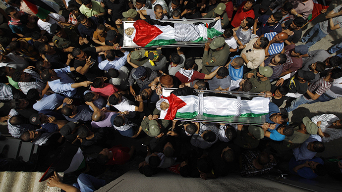Mourners carry the bodies of two Palestinians, who were shot dead by Israeli forces on Thursday, during their funeral in the West Bank city of Ramallah May 16, 2014. (Reuters / Mohamad Torokman)