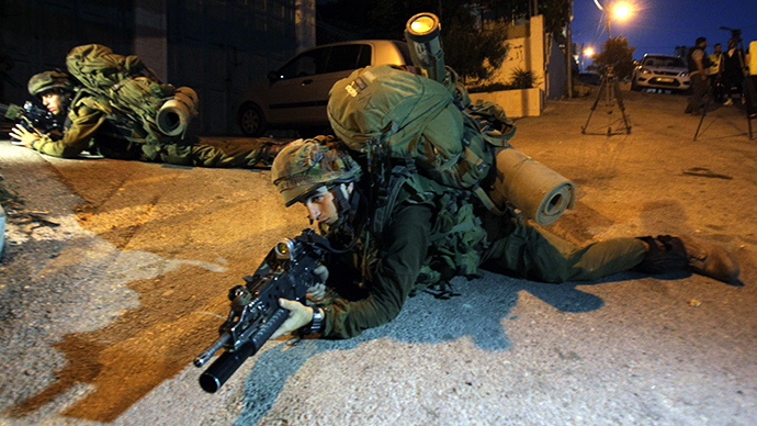 Israeli soldiers patrol an area in the West Bank town of Hebron on June 15, 2014, as they search for three teenagers who went missing near a West Bank settlement. (AFP Photo / Hazem Bader)