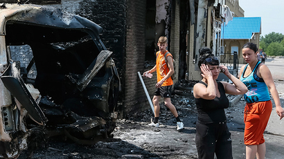 Local residents react as they stand near destroyed houses and vehicles after what locals say was overnight shelling by Ukrainian forces, in the eastern Ukrainian town of Slavyansk June 9, 2014 (Reuters / Gleb Garanich)