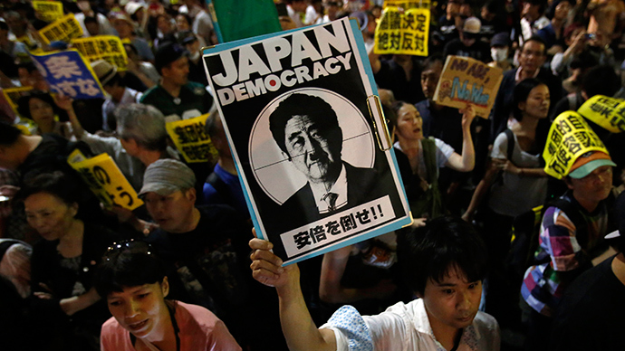 Protesters holding placards shout slogans at a rally against Japan's Prime Minister Shinzo Abe's push to expand Japan's military role in front of Abe's official residence in Tokyo June 30, 2014 (Reuters / Yuya Shino)