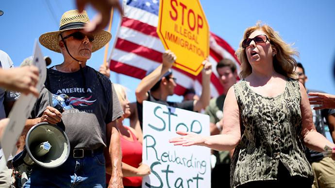 Immigrant rights activist Mary Estrada (R) speaks with anti-immigration activists during a protest outside of the U.S. Border Patrol Murrieta Station on July 7, 2014 in Murrieta, California (Reuters / Sandy Huffaker)