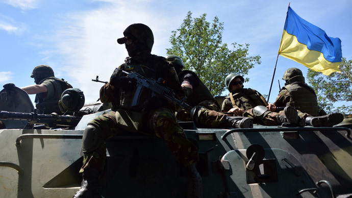 Ukrainian troops sit atop an armoured personnel carrier (APC) fitted with a Ukrainian flag as a convoy rides past near the eastern Ukrainian city of Kramatorsk, in the Donetsk region (AFP Photo / Genya Savilov)