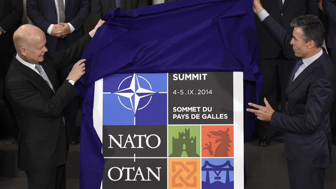 British Foreign Secretary of State for Foreign an Commonwealth Affairs, William Hague (L) and NATO Secretary General Anders Fogh Rasmussen unveils the logo of the NATO Wales' summit before a family picture as part of a Foreign Affairs Ministers meeting in Brussels on June 25, 2014. (AFP Photo)