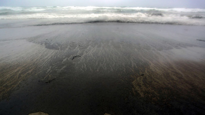 The oil slick from the grounded container ship 'Rena' stains Papamoa Beach near Tauranga (AFP Photo)