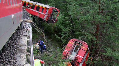 This handout picture taken and released by the police of the Canton of Graubuenden on August 13, 2014 shows rescuers working near a train after it was derailed by a landslide near Tiefencastel, in a mountainous part of eastern Switzerland, on August 13, 1014. (AFP Photo)