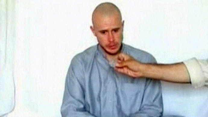 U.S. Army Private Bowe Bergdahl watches as one of his captors displays his identity tag to the camera at an unknown location in Afghanistan, July 19, 2009. (Reuters)