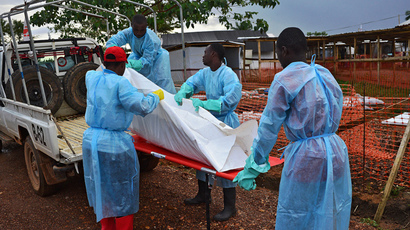Sierra Leone government burial team members load the body of an Ebola victim onto a truck at an MSF facility in Kailahun, on August 14, 2014. (AFP Photo / Carl de Souza) 