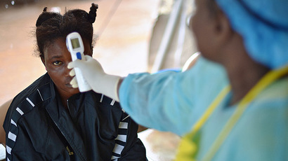 A girls suspected of being infected with the Ebola virus has her temperature checked at the government hospital in Kenema, Sierra Leone, on August 16, 2014. (AFP Photo / Carl de Souza)