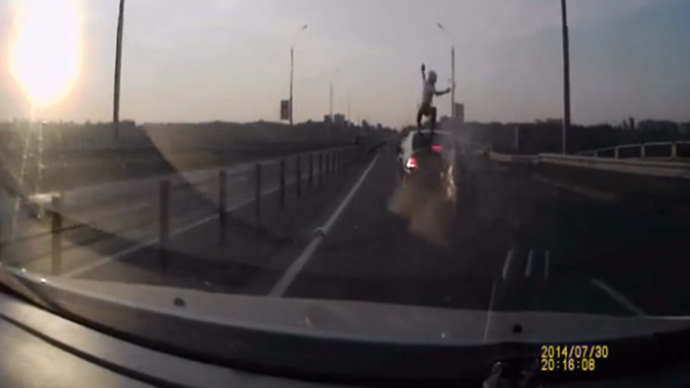 Biker survives rear-ending car by vaulting on to its roof (VIDEO)