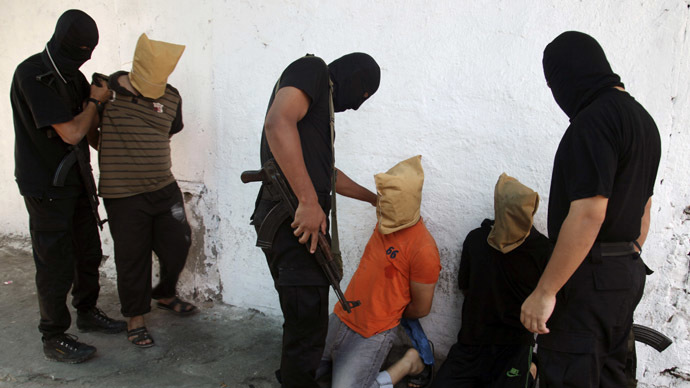 Hamas militants grab Palestinians suspected of collaborating with Israel, before executing them in Gaza City August 22, 2014. (Reuters)