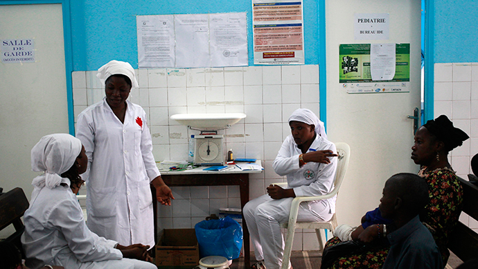 Nurses talk near a poster (C) displaying a government message against Ebola, at a maternity hospital in Abidjan (Reuters / Luc Gnago)