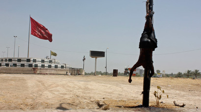 The body of a man is hung upside down in the city of Baquba August 2, 2014. (Reuters / Stringer)