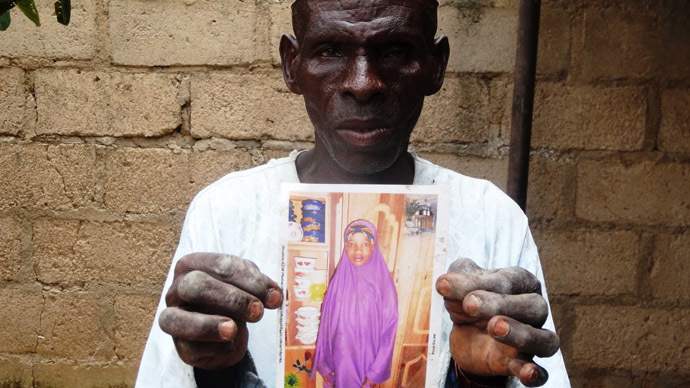 Wasila&#39;s father-in-law, Sani Garba, holding a picture of the 14-year-old (AFP Photo/Aminu Abubakar) / AFP - 000_par7949851
