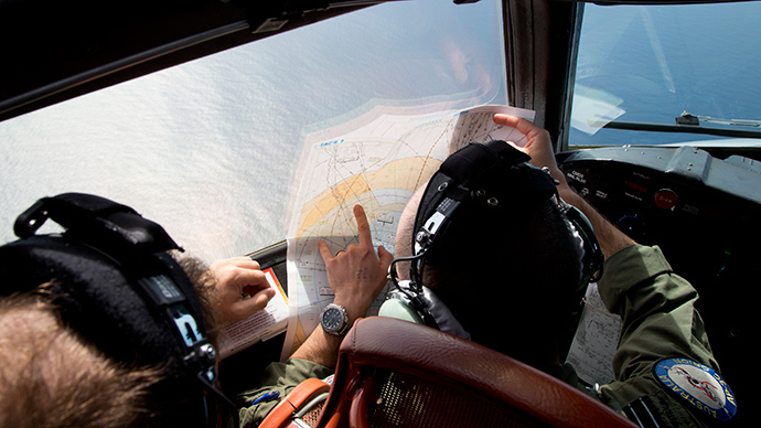 Flight lieutenant Jayson Nichols looks at a map as he flies aboard a Royal Australian Air Force AP-3C Orion aircraft searching for the missing Malaysian Airlines flight MH370 over the southern Indian Ocean on March 27, 2014 (AFP Photo / Pool)