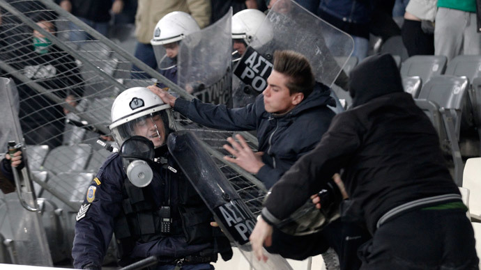‘We came for football, not war!’ Fans throw flares, storm field during Greek champions’ match