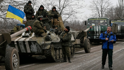 A member of Special Monitoring Mission of the Organization for Security and Cooperation (OSCE) to Ukraine walks along a convoy of Ukrainian armed forces in Paraskoviyvka, eastern Ukraine, February 26, 2015 (Reuters / Gleb Garanich)