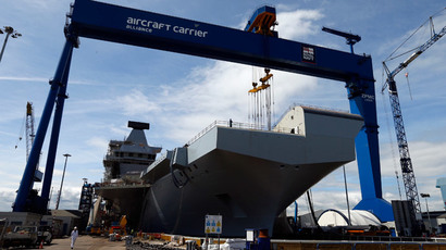 Workers walk in front of HMS Queen Elizabeth.(Reuters / Russell Cheyne)