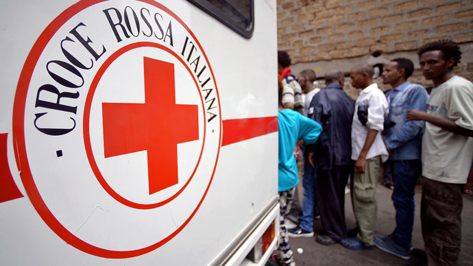Migrants queue near a vehicle of the Italian Red Cross outside 'Baobab' migration centre next to the Tiburtina train station in Rome on June 14, 2015. (AFP Photo / Filippo Monteforte )