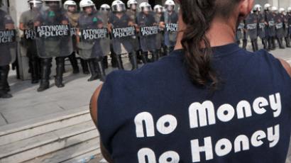 A shipyard worker stands in front of riot policemen guarding the Greek Police headquarters, during a protest to demand the release of some 100 colleagues that were arrested earlier after breaking in to the Defense Ministry in Athens on October 4, 2012.  (AFP Photo/Louisa Gouliamaki)