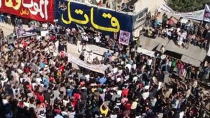 Anti-regime protesters standing under banners that read in Arabic "Killer" and "Death rather than humilation" during a pro-democracy rally in Dael, on the outskirts of Daraa, November 11, 2011. AFP PHOTO/YOUTUBE