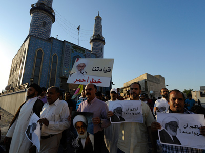 Protesters carry pictures of Shi'ite scholar Isa Qassim during an anti-government protest in the village of Diraz, west of Manama, November 2, 2012 (Reuters / Stringer)