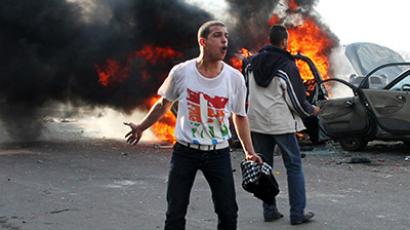 An anti-Morsi protester shouts slogans in front of burning cars during clashes with Morsi supporters in Alexandria December 14, 2012. (Reuters/Stringer)