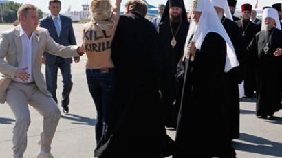 Security guards detain a FEMEN activist as she protests against the visit of the head of the Russian Orthodox Church, Patriarch Kirill (2rd R), to Ukraine in Borispol airport, near the Ukrainian capital of Kiev July 26, 2012 (Reuters / Gleb Garanich)