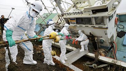 Volunteers to remove radioactive substances from a fishing boat in Minamisoma, Fukushima Prefecture, in this photo taken by Kyodo October 24, 2011. (Reuters / Kyodo)