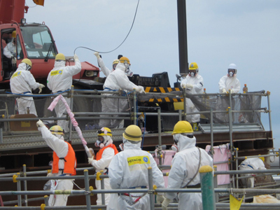 Workers wearing protective suits, work for removing unused nuclear fuel assemblies stored in the spent fuel pool of TEPCO's tsunami-crippled Fukushima Daiichi Nuclear Power Plant No. 4 reactor building in Fukushima prefecture (Reuters / Tokyo Electric Power Co / Handout)