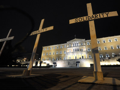 Crosses reading 'Solidarity', 'Dignity ' and 'Freedom' are placed in front of the Greek parliament following the suicide of a retired pharmacist who shot himself. (AFP Photo/Louisa Gouliamaki)