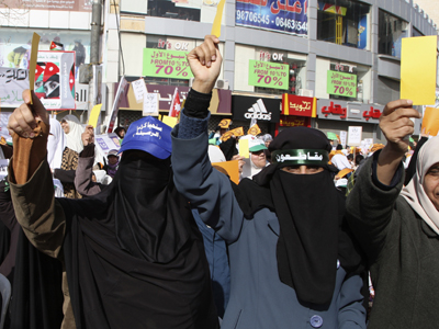 Protesters from the Islamic Action Front and other opposition parties hold signs reading "Boycotting" during a protest in Amman January 18, 2013. (Reuters / Majed Jaber)