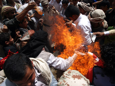 Yemeni protesters burn a US flag during a demonstration at a street leading to the US embassy in Sanaa on September 14, 2012 against a film mocking Islam. (AFP Photo/Mohammed Huwais)