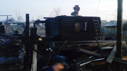 Debris left of the house in Nizhnyaya Poyma - RIA Novosti