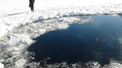 A Russian policeman works near an ice hole, said by the Interior Ministry department for Chelyabinsk region to be the point of impact of a meteor seen earlier in the Urals region, at lake Chebarkul some 80 kilometers (50 miles) west of Chelyabinsk February 15, 2013 (Reuters / Chelyabinsk region Interior Ministry)