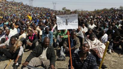 A protester holds a placard outside a South African mine in Rustenburg (Reuters/Siphiwe Sibeko)