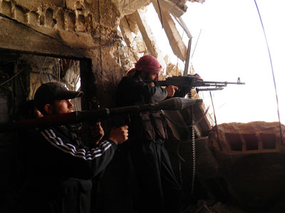 Free Syrian Army fighters with weapons stand guard at the frontline against forces loyal to Syrian President Bashar al-Assad in the Al-khalidiya neighbourhood of Homs.(Reuters / Handout)