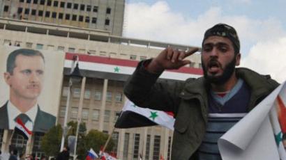 Damascus: A Syrian government supporter holds a portrait of President Bashar al-Assad during a pro-regime rally in Damascus on January 26, 2012 (AFP Photo/Louai Beshara)